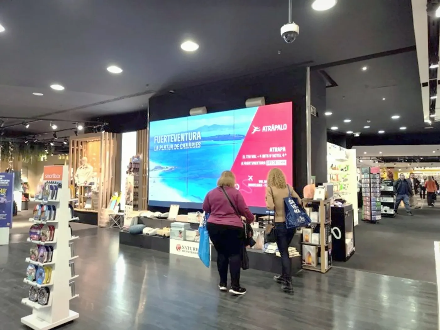 Pantalla grande en una tienda con clientes mirándola